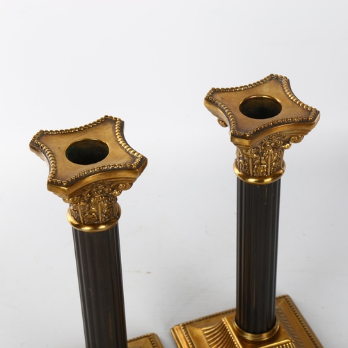 1042 - A pair of French patinated brass Corinthian column candlesticks, late 19th/early 20th century, heigh... 