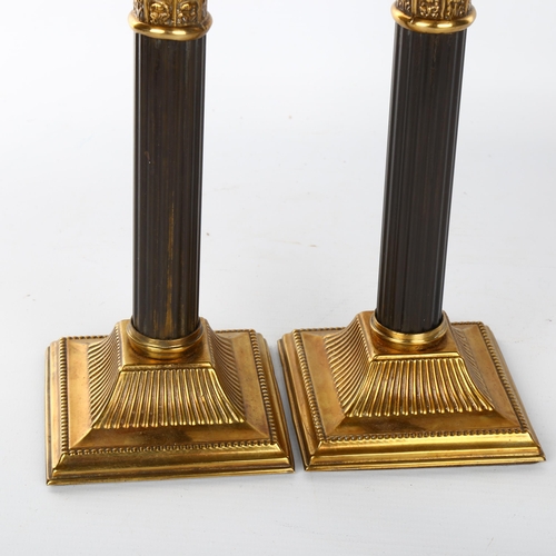 1042 - A pair of French patinated brass Corinthian column candlesticks, late 19th/early 20th century, heigh... 