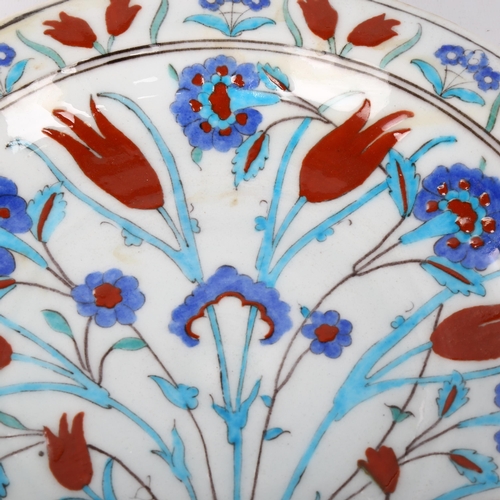 1044 - A Middle Eastern Iznik polychrome glazed pottery plate with floral design, diameter 31cm