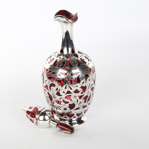 1048 - A 19th century cranberry glass and silver overlay decanter and stopper, height 22cm