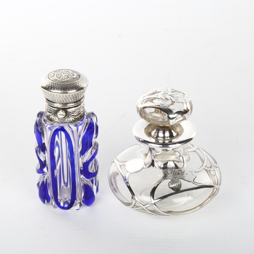 1049 - A Victorian blue overlay perfume bottle with hinged unmarked white metal top, height 9cm, and a clea... 