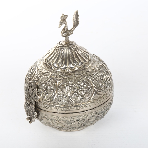 1050 - An unmarked Indian white metal box, with hinged lid and peacock knop, height 13cm, diameter 10cm