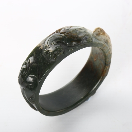 1058 - A relief carved jade bangle, internal diameter 7cm, width 2.5cm