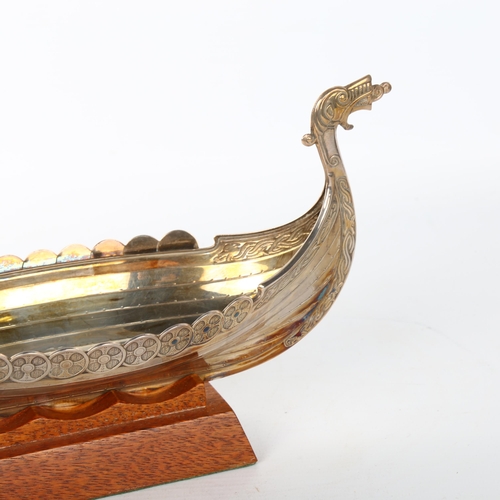 1080 - A Scandinavian electroplate table centre bowl, in the form of a Viking longboat, on hardwood stand, ... 