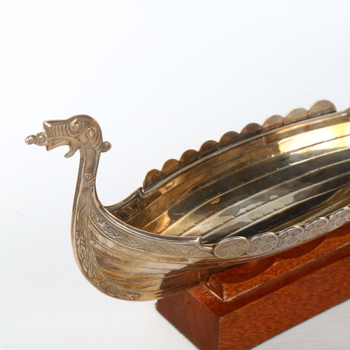 1080 - A Scandinavian electroplate table centre bowl, in the form of a Viking longboat, on hardwood stand, ... 