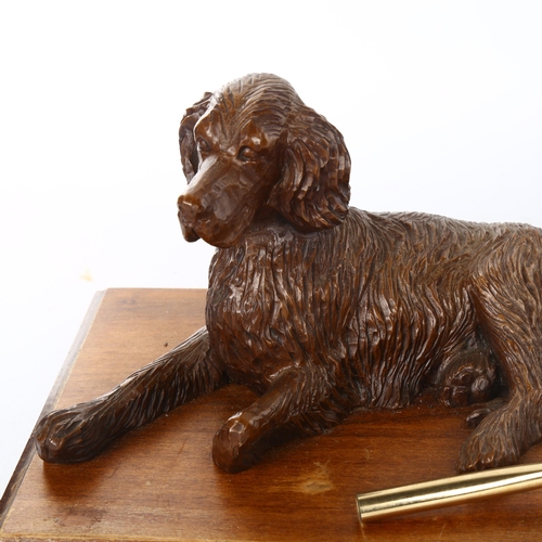 1103 - A carved wood desk stand surmounted by a reclining dog, early 20th century, length 25cm