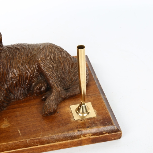 1103 - A carved wood desk stand surmounted by a reclining dog, early 20th century, length 25cm