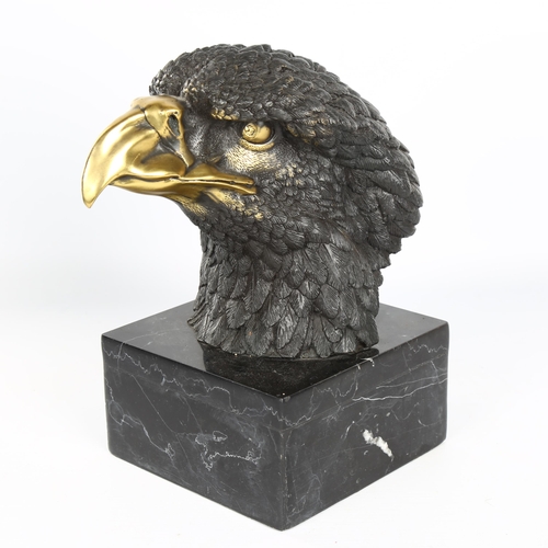 1121 - A parcel-gilt bronze eagle-head sculpture on black marble base, unsigned, height 25cm