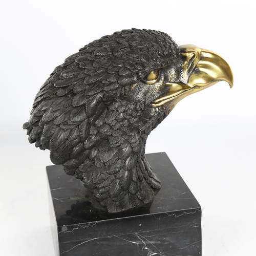 1121 - A parcel-gilt bronze eagle-head sculpture on black marble base, unsigned, height 25cm