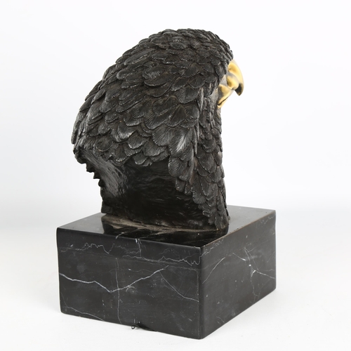 1121 - A parcel-gilt bronze eagle-head sculpture on black marble base, unsigned, height 25cm