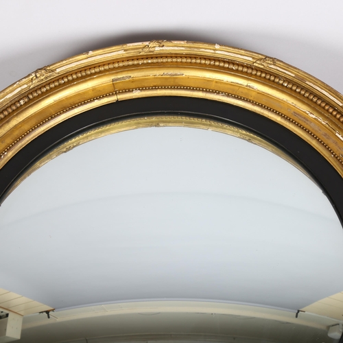 1135 - A large 19th century gilt-gesso framed convex wall mirror, overall diameter 86cm