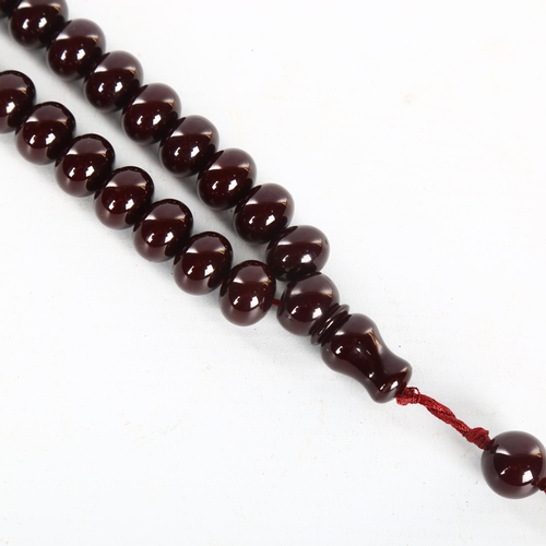 1151 - A string of polished/lacquered wood prayer beads, with tassel, overall length including tassel 51cm