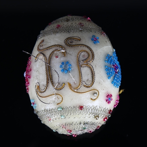 1193 - An Antique wax egg, possibly Russian, with bead and wirework decoration