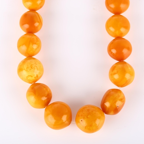 125 - A graduated single-strand butterscotch amber bead necklace, beads ranging from 26.9mm to 23mm, neckl... 