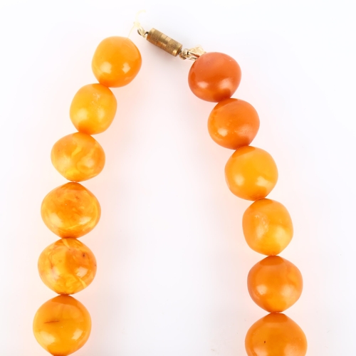 125 - A graduated single-strand butterscotch amber bead necklace, beads ranging from 26.9mm to 23mm, neckl... 