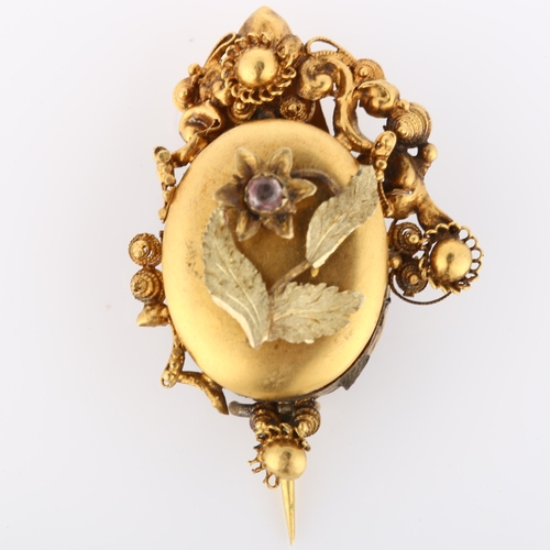 149 - A Victorian Etruscan style mourning brooch, with stone set flower motif, cannetille surround and mem... 