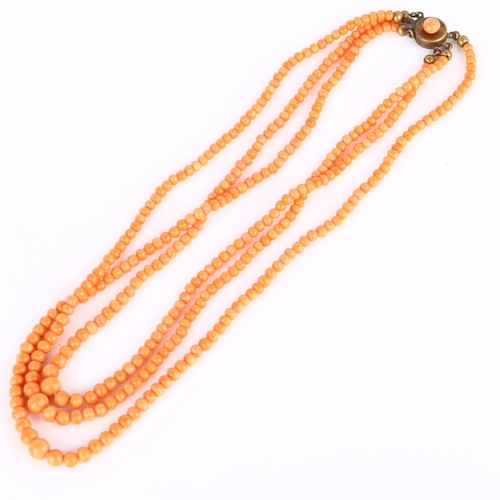 236 - A triple-strand graduated coral bead necklace, with gilt-metal clasp, beads ranging from 6.3mm - 2.6... 