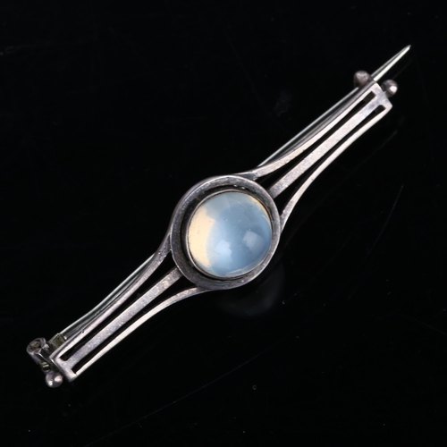 259 - An Arts and Crafts moonstone bar brooch, unmarked silver settings with round high cabochon moonstone... 