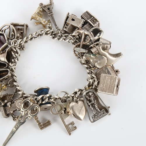 348 - A silver curb link charm bracelet, with large quantity of charms and silver heart padlock clasp, bra... 