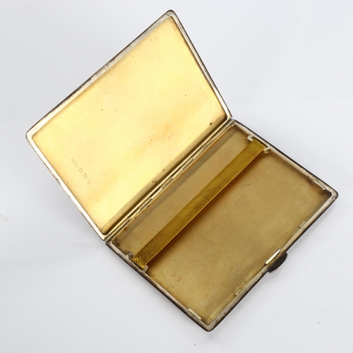 509 - An Elizabeth II rectangular silver cigarette case, allover engine turned decoration with gilt interi... 