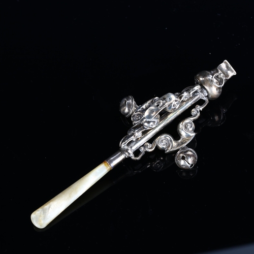 532 - A George V silver baby's rattle/whistle, with mother-of-pearl handle and openwork foliate design, by... 