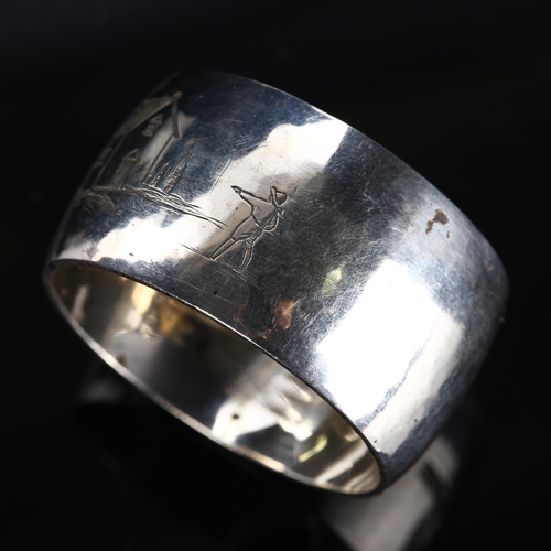 535 - ASPREY & CO LTD - a George VI silver napkin ring, planished decoration with engraved figure looking ... 