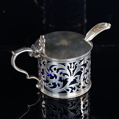 540 - A Victorian silver drum mustard pot and spoon, pierced foliate decoration with thumbpiece, blue glas... 