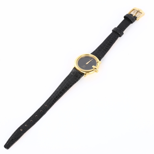 57 - GUCCI - a lady's gold plated quartz wristwatch, black dial with G-shaped case, serial no. 313600413,... 