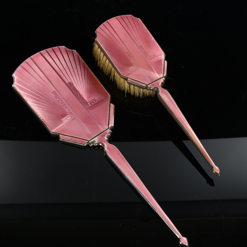 572 - An Art Deco silver and pink enamel 2-piece dressing table set, comprising hand mirror and hair brush... 