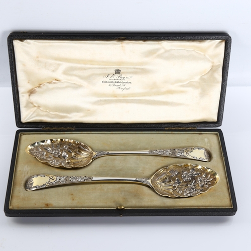 587 - A pair of George III silver Old English pattern berry spoons, bright-cut engraved and relief embosse... 