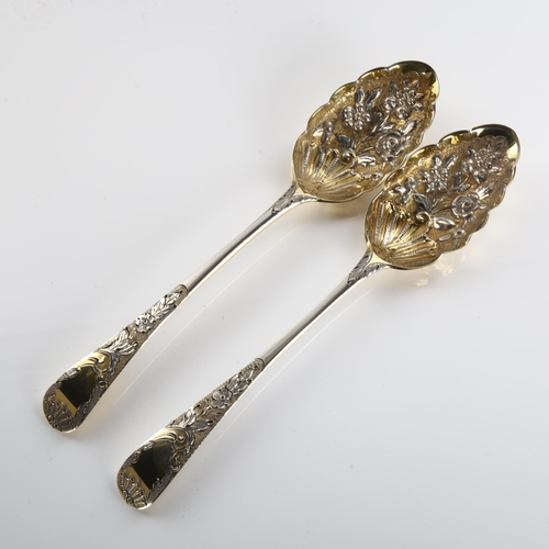 587 - A pair of George III silver Old English pattern berry spoons, bright-cut engraved and relief embosse... 