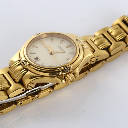 59 - GUCCI - a lady's gold plated 9240L quartz bracelet watch, cream dial with gilded baton hour markers,... 