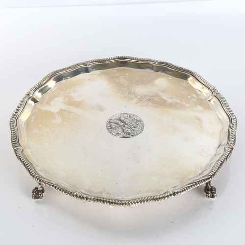 618 - A George V circular silver salver, gadrooned rim with claw and ball feet, by Goldsmiths & Silversmit... 