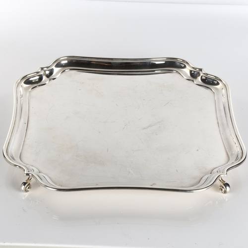 619 - An Art Deco George V square silver salver, shaped rim with scrolled feet, by Mappin & Webb, hallmark... 