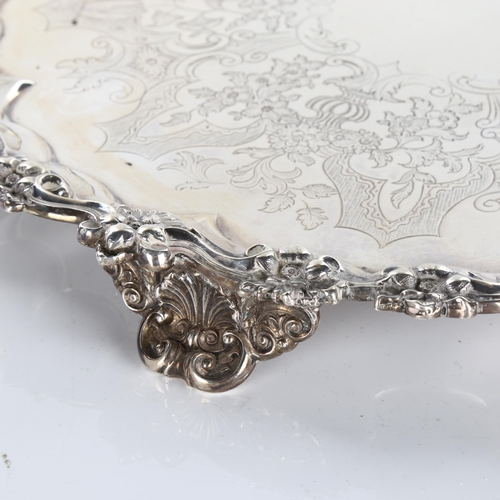 621 - A large and heavy Victorian silver tray, circular form with lobed and cast floral rim, central folia... 