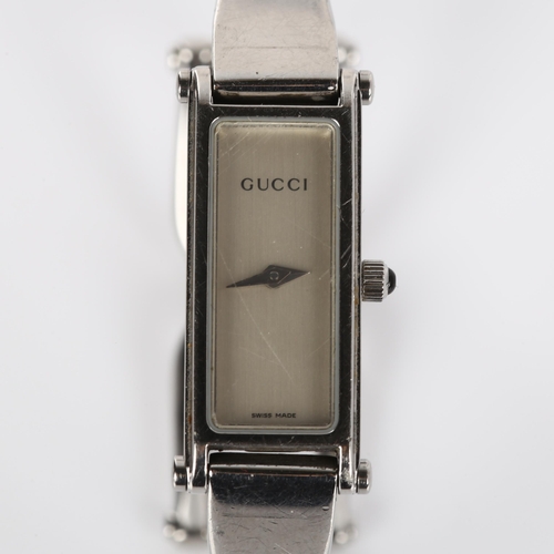 63 - GUCCI - a lady's stainless steel 1500L quartz bracelet watch, silvered dial with cabochon crown and ... 