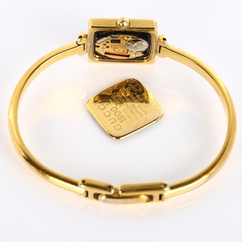 64 - GUCCI - a lady's gold plated 1900L quartz bracelet watch, square white dial with bangle bracelet, se... 