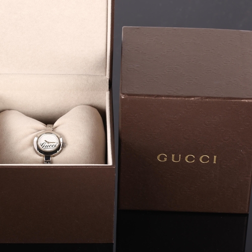 23 - GUCCI - a lady's stainless steel quartz bracelet watch, ref. 105, Gucci GG monogram dial with bangle... 