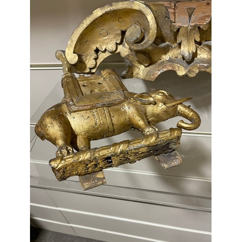 1140 - A 19th century carved giltwood-framed wall mirror, surmounted by an elephant armorial crest, overall... 