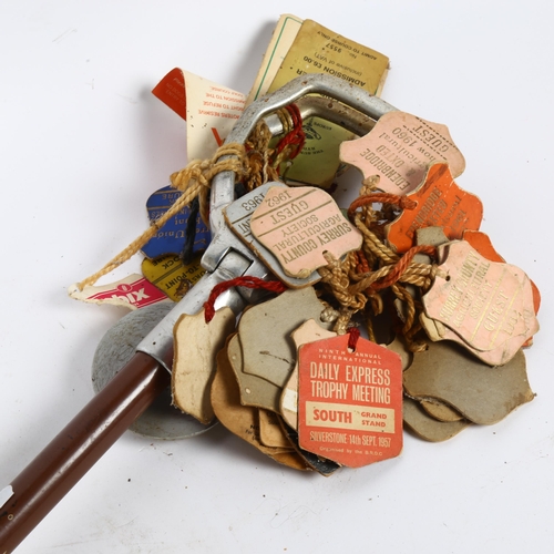 29 - A mid-20th century aluminium shooting stick, with various paddock passes and badges, including 1956 ... 