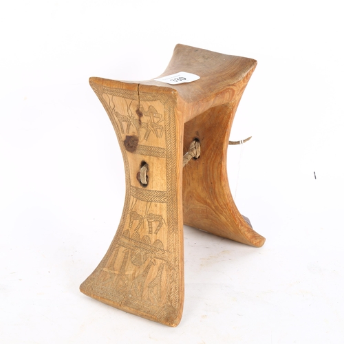 330 - An African wood neck rest with engraved sides, height 19cm