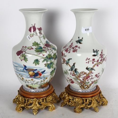 A pair of decorative Chinese vases with bird designs, on gilded cast