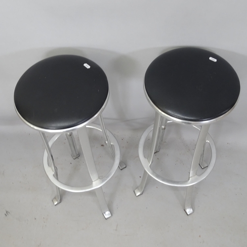 2173 - A pair of mid-century industrial design bar stools, with black leather upholstery, on brushed steel ... 