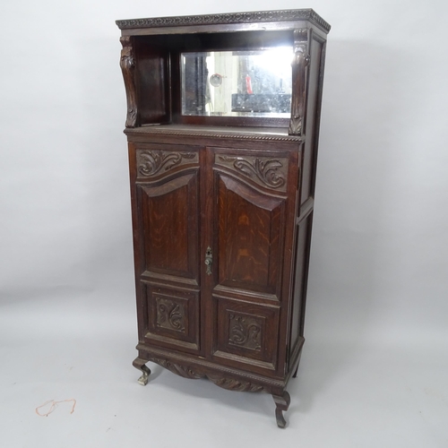 2009 - A 19th century mahogany music cabinet, with raised mirrored back and 2 panelled doors with carved de... 