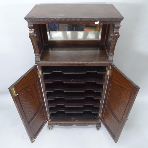 2009 - A 19th century mahogany music cabinet, with raised mirrored back and 2 panelled doors with carved de... 