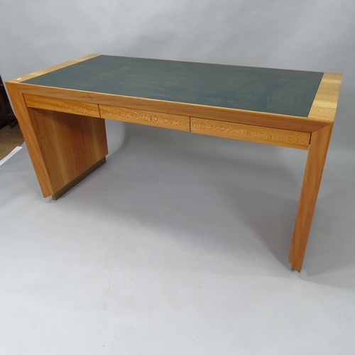 2015 - A contemporary teak kneehole writing desk, with label for Rolex, having inlaid green leather skiver ... 