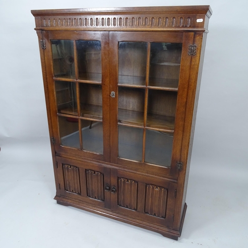 2024 - An oak 2-door bookcase, with linenfold carved decoration and cupboards under, 97cm x 137cm x 31cm (w... 