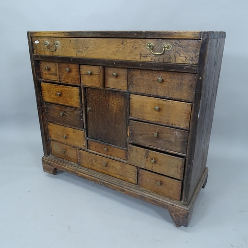 2035 - An Antique stained pine bank of 16 drawers, with single central cabinet, on bracket feet, 92cm x 88c... 