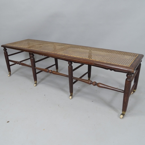 2047 - A Victorian window seat with caned panel, turned spindles and original casters, 137cm x 39cm x 39cm