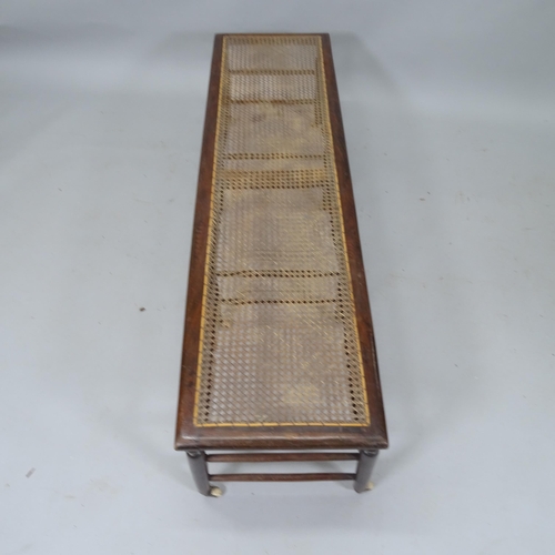 2047 - A Victorian window seat with caned panel, turned spindles and original casters, 137cm x 39cm x 39cm